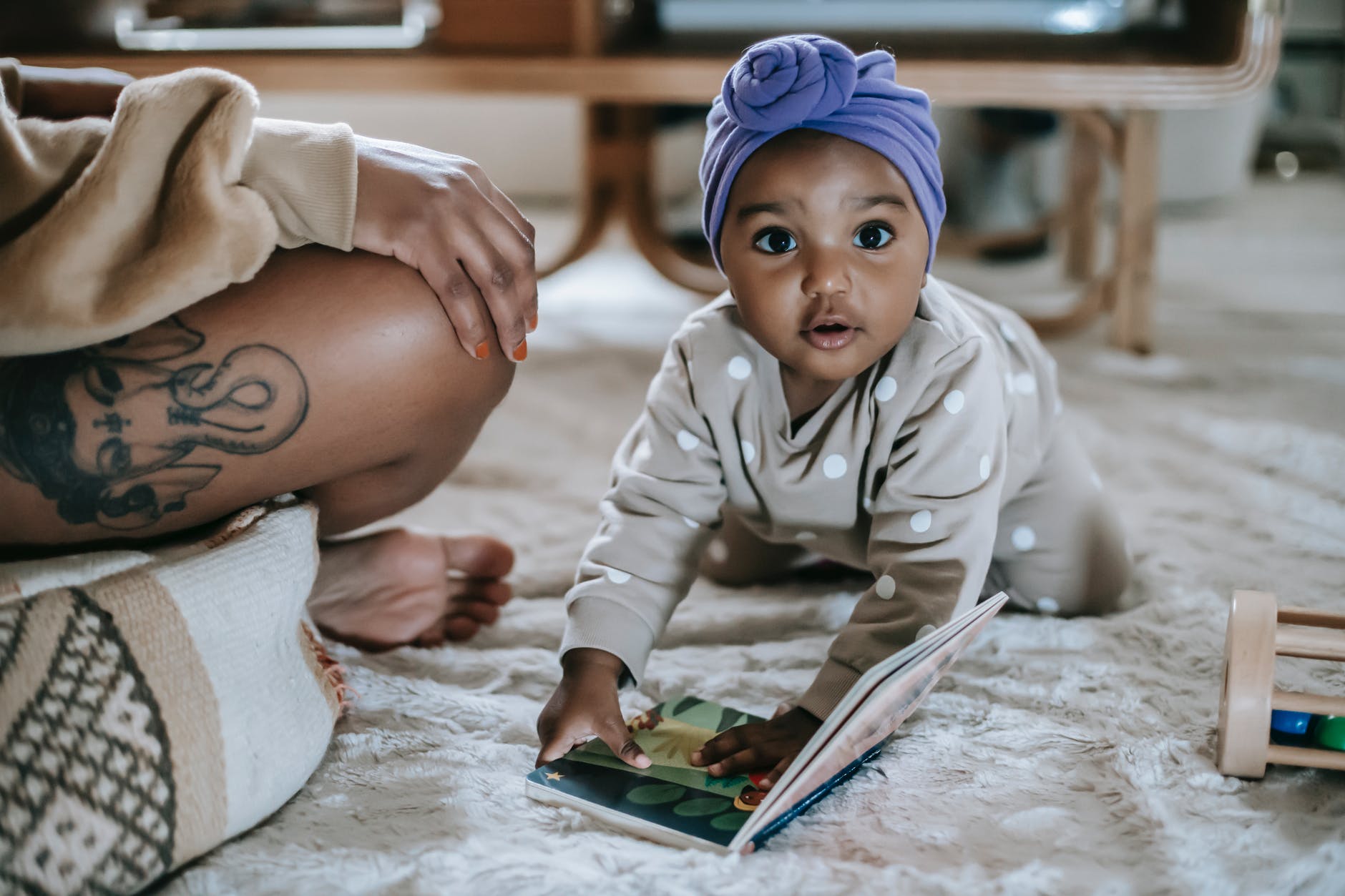 Baby reading book with single mother in background

Photo by William  Fortunato on Pexels.com